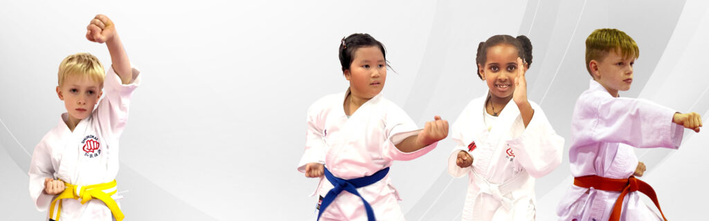 Young martial arts students wearing uniforms practicing punches in a karate class
